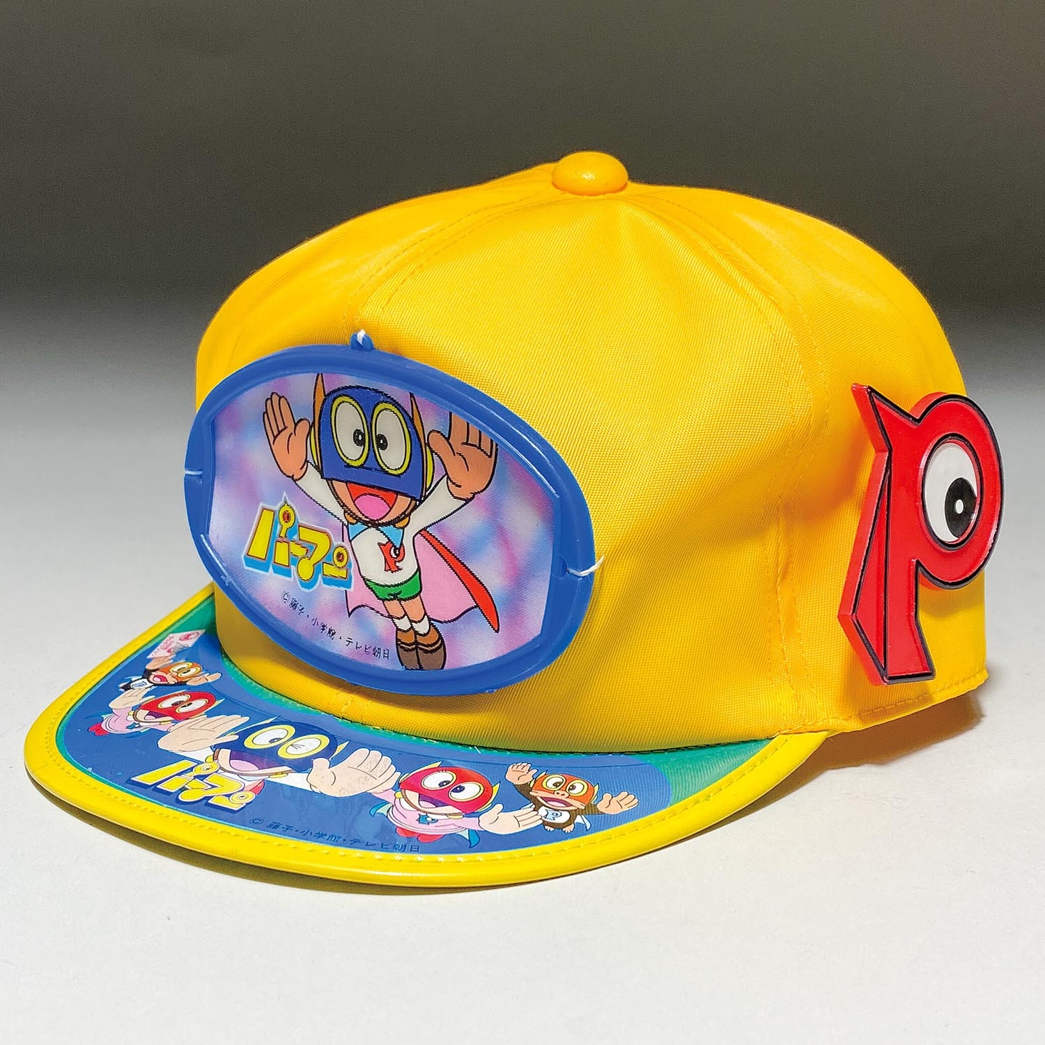 1254］ 岩井 パーマン帽子 黄色 アジャスター付 Pバッジ 55cm